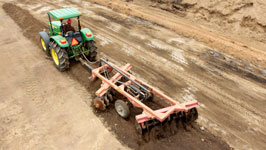 Agricultural tractor with harrow